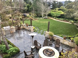 A patio with stone flooring, outdoor furniture, and a fire pit. - Grand Craftsman Estate built in 1937 Charms in the heart of Carmel By The Sea (Carmel)