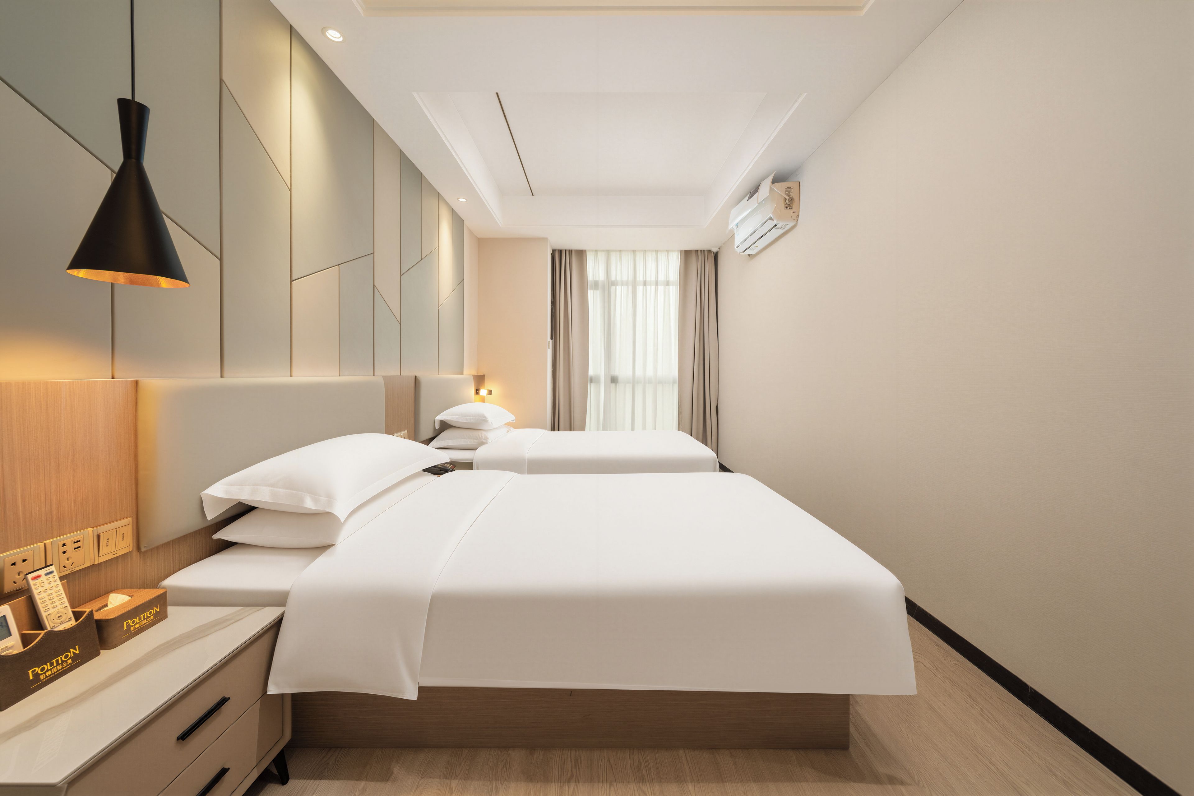 A modern hotel room with a large bed, bedside tables, a lamp, and a window with curtains.