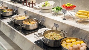 A buffet with various dishes including dumplings, vegetables, and fruits. - Poltton International Service Apartment (Foshan Yingtian Plaza Wanhua Metro Station (Foshan)