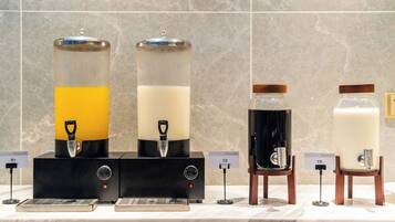 Four beverage dispensers with labels indicating different drinks.