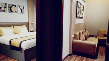 A hotel room with a bed, a sofa, and a small table.