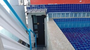 Ein Poolbereich mit blau gefliestem Boden, einer weißen und blauen Struktur und einer Tür mit der Nummer 01.