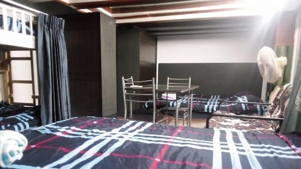 A room with a bed, a chair, a table, and a fan. - Room-charming Family Guest Room for 6 gu (Pattaya)