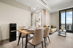 Un soggiorno moderno con zona pranzo, divano e vista sulla città.