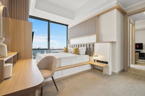 Ein modernes Schlafzimmer mit großem Fenster, einem Bett mit Kopfteil, einem Schreibtisch und einem Stuhl.