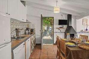 A kitchen with a dining area, a TV, and a fireplace.