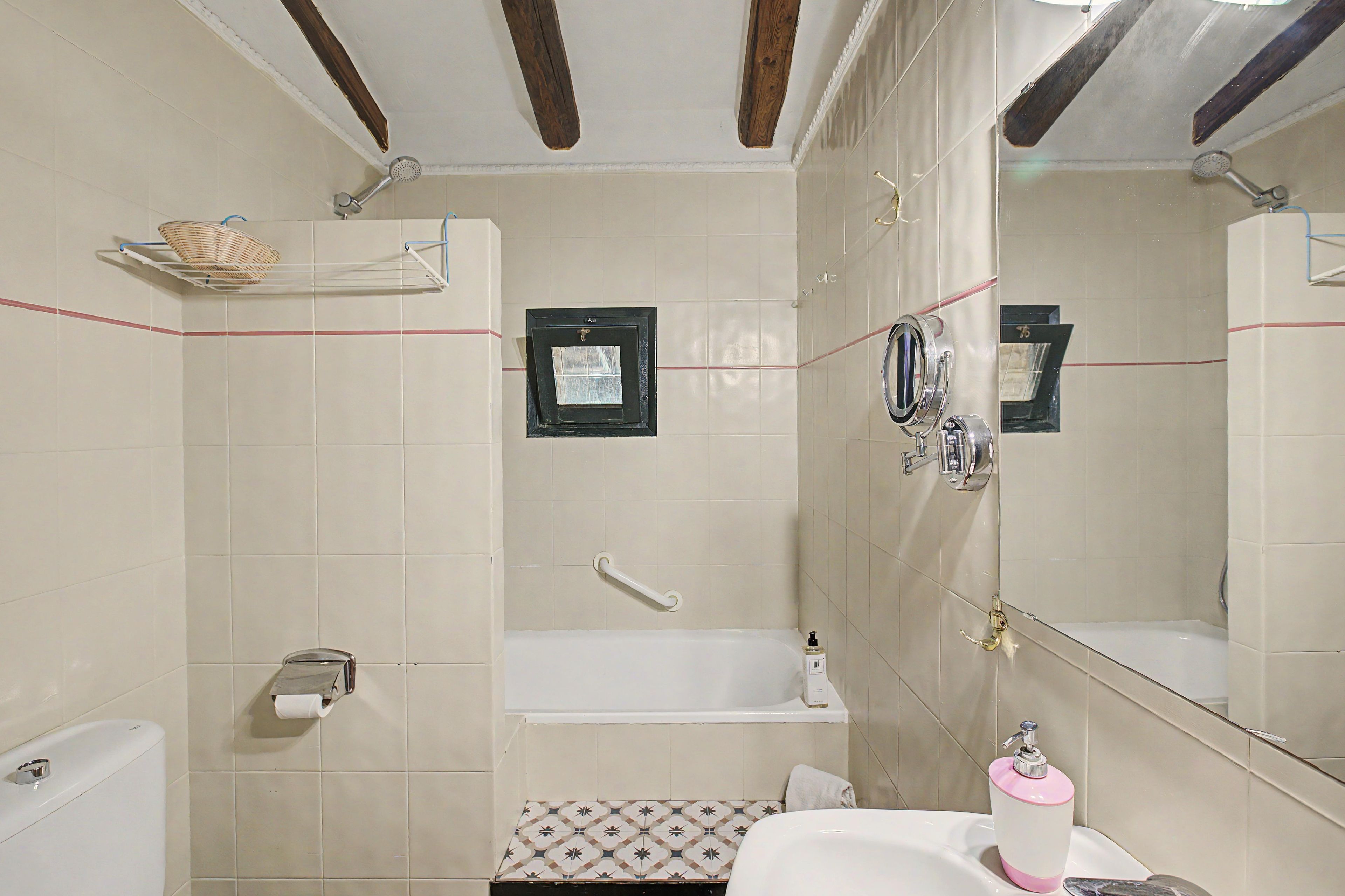 Een badkamer met een bad, douche, toilet en wastafel.