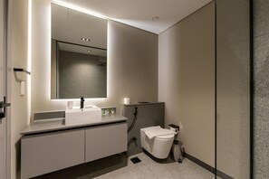 A modern bathroom with a large mirror, a white sink, a toilet, and a trash can. - MAG EYE 890 - Modern Studio Near Downtown (Meydan)