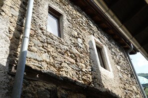 A stone building with two windows and a metal pipe. - Casa Holamundo, authentic 1900 Stone House in the Mountains near Lugano (Curtina)