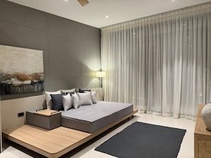 A modern bedroom with a large bed, a bedside table, a wall-mounted lamp, and a large window with curtains. - Villa Ramay - Boutique Pool Villa - 5 Minutes to Fisherman's Village (Amphoe Ko Samui)