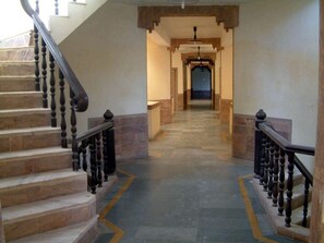 Una escalera de piedra con barandilla de madera que conduce a un rellano.