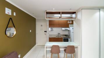Una cocina compacta con comedor, un espejo y un armario con puerta corredera.