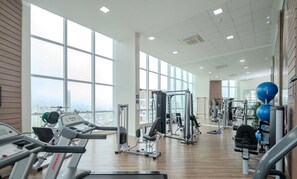 A gym with treadmills, weight machines, and exercise balls.