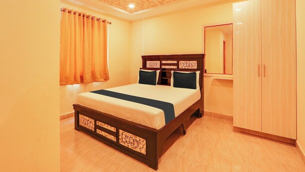 A bedroom with a bed, a wardrobe, a ceiling fan, and a window with curtains.