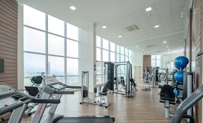Ein geräumiges Fitnessstudio mit Laufbändern, Kraftgeräten und Trainingsbällen.