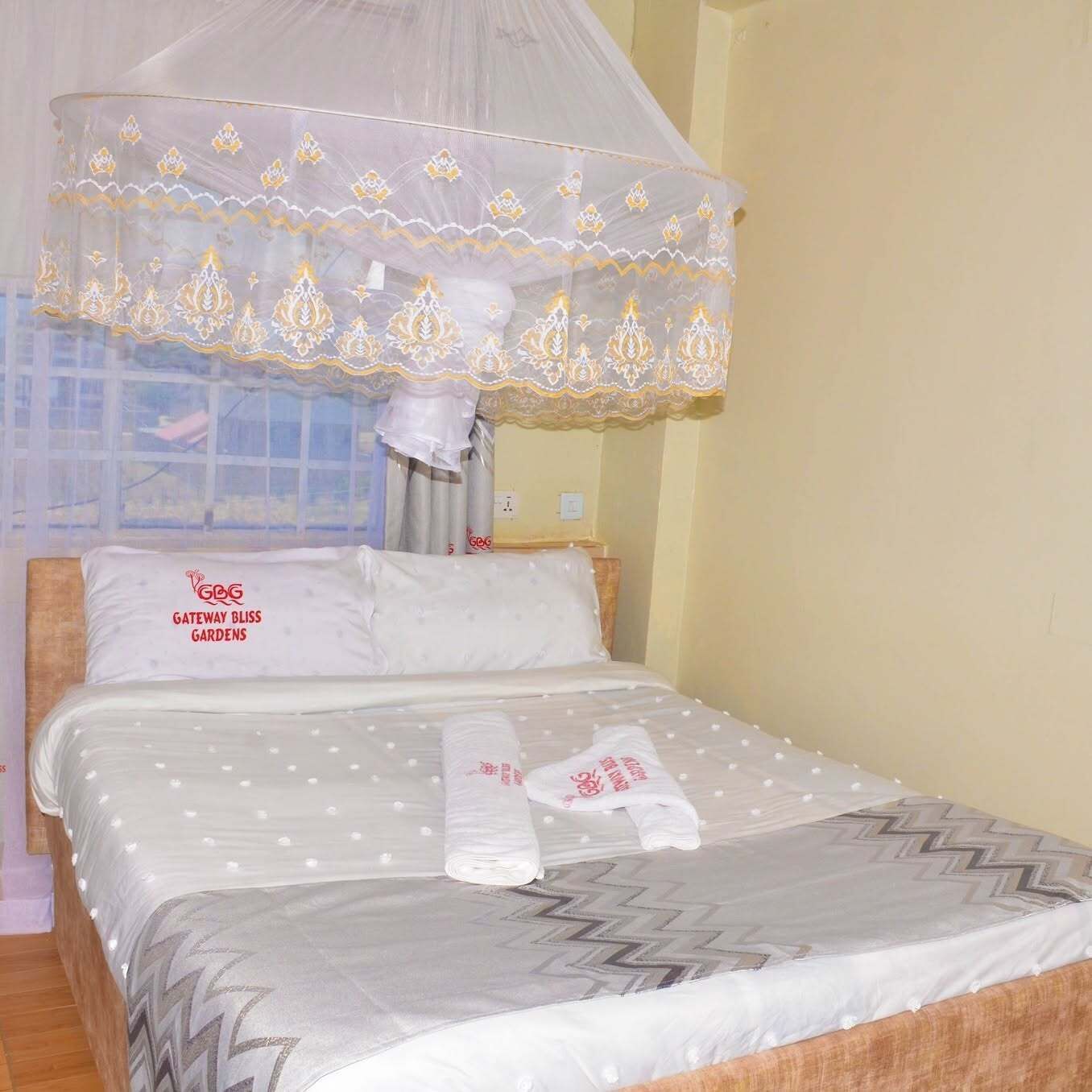 Una cama con dosel, almohadas y una manta.