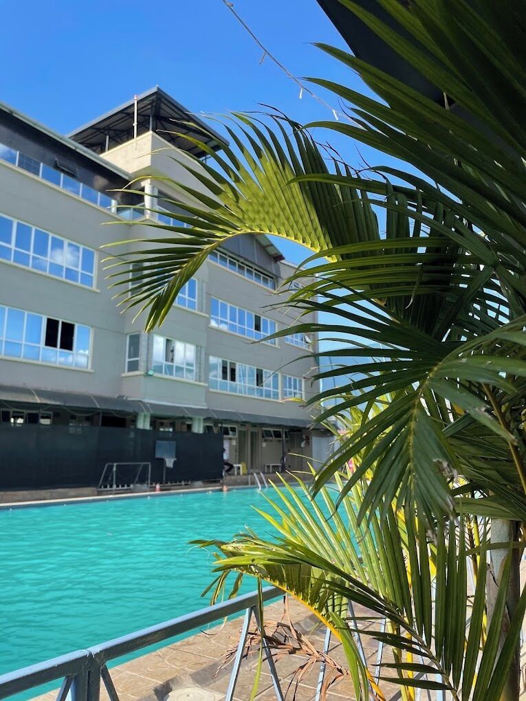 Una piscina con un edificio al fondo.