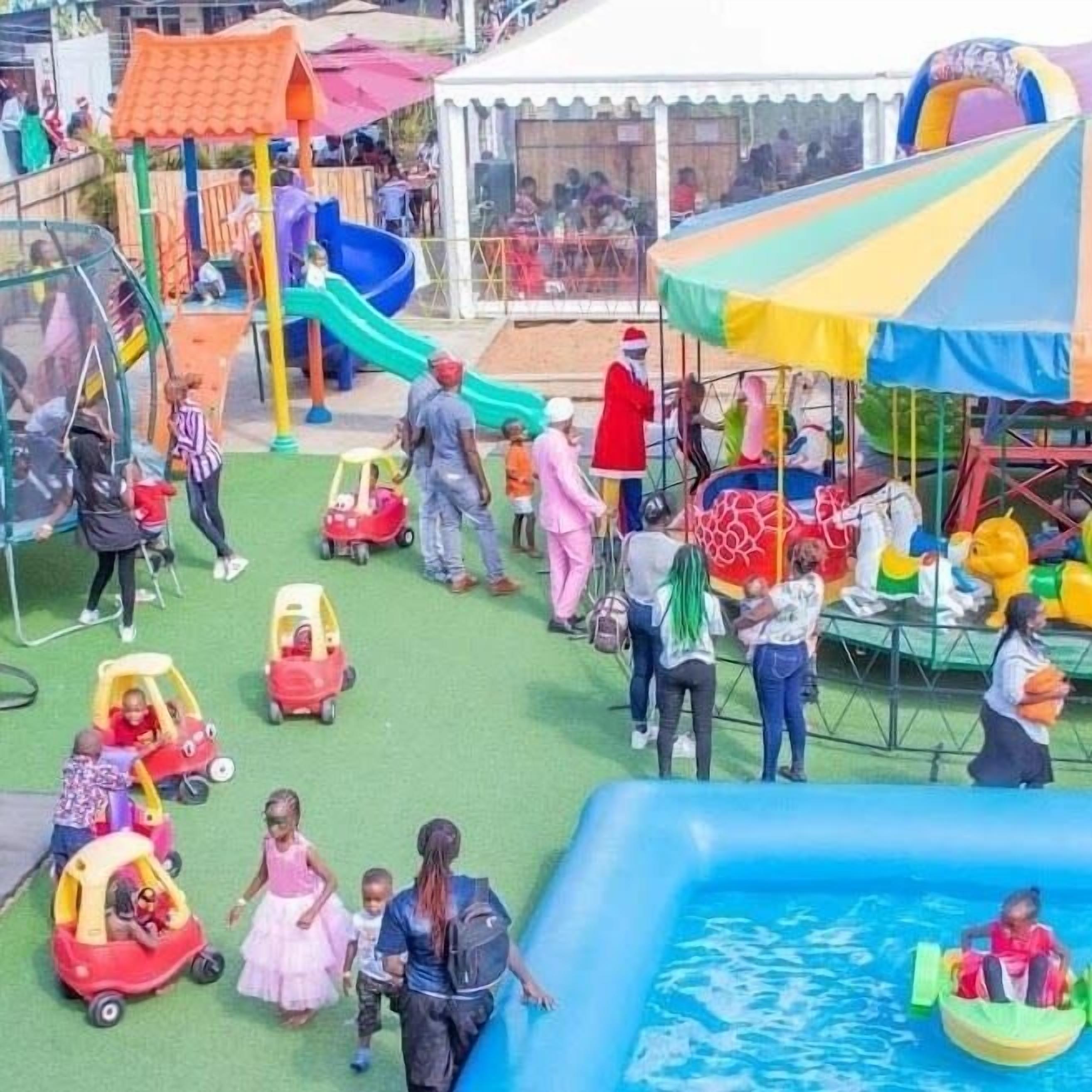 Un área de juegos para niños con toboganes, una piscina pequeña y diversas estructuras recreativas.