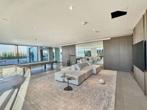 Un salon moderne avec un canapé d’angle, une table basse et un téléviseur à écran plat.
