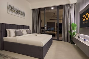 A modern hotel room with a large bed, a sliding glass door to a balcony, and a flat-screen TV mounted on the wall. - Chic Studio | Pool View Balcony | Avelon Arjan (Dubai)