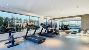 A modern gym with treadmills, stationary bikes, and elliptical machines. - Chic Studio | Pool View Balcony | Avelon Arjan (Dubai)