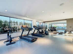 Ein modernes Fitnessstudio mit Laufbändern, Ergometer und Crosstrainern.