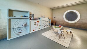 A modern interior with a central round table, white cabinets with geometric patterns, and a large circular wall feature. - Chic Studio | Pool View Balcony | Avelon Arjan (Dubai)