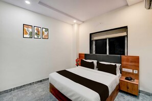 Un dormitorio moderno con cama, mesitas de noche, ventana y decoración en la pared.