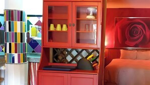 A room with a red cabinet, a bed with a white headboard, and a colorful geometric wall design. - ‘Zentralclub La Osera’ Apartment with Mountain Views, Terrace & Shared Garden (Las Viñas)