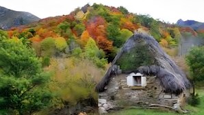 A traditional thatched-roof house with a stone foundation, surrounded by a forested hillside. - ‘Zentralclub La Osera’ Apartment with Mountain Views, Terrace & Shared Garden (Las Viñas)