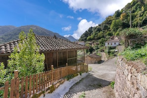A rural village with traditional stone houses, a wooden fence, and a clear path leading through the village. - ‘Zentralclub La Osera’ Apartment with Mountain Views, Terrace & Shared Garden (Las Viñas)