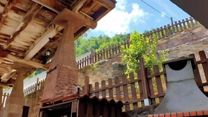A rustic wooden structure with a stone wall and a wooden fence. - ‘Zentralclub La Osera’ Apartment with Mountain Views, Terrace & Shared Garden (Las Viñas)