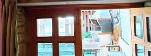 Ventana de madera con vista a un balcón y zona exterior.