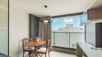 A modern dining area with a round table, chairs, and a pendant light.