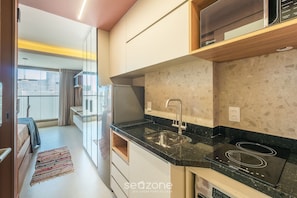 Eine moderne Küche mit Einbauherd, Spüle und Kühlschrank.