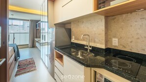 A modern kitchen with a built-in stove, a sink, and a refrigerator. - Studio Near the Beach in Condo w/ Pool Edf0207 (Salvador)