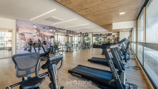 Un gimnasio con cintas de correr, bicicletas estáticas y máquinas de pesas.