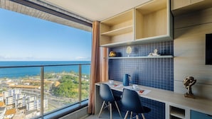 Cocina moderna con vista al océano, comedor con sillas y un ventanal grande.