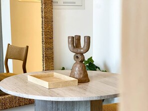 A round table with a wooden candelabra and a rectangular tray. - Modern Studio in JVC | Pool, Gym & BBQ Access (Dubai)