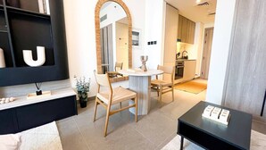 Uma sala de estar moderna com um sofá, uma mesa de centro e um espaço de jantar com cadeiras e uma mesa.