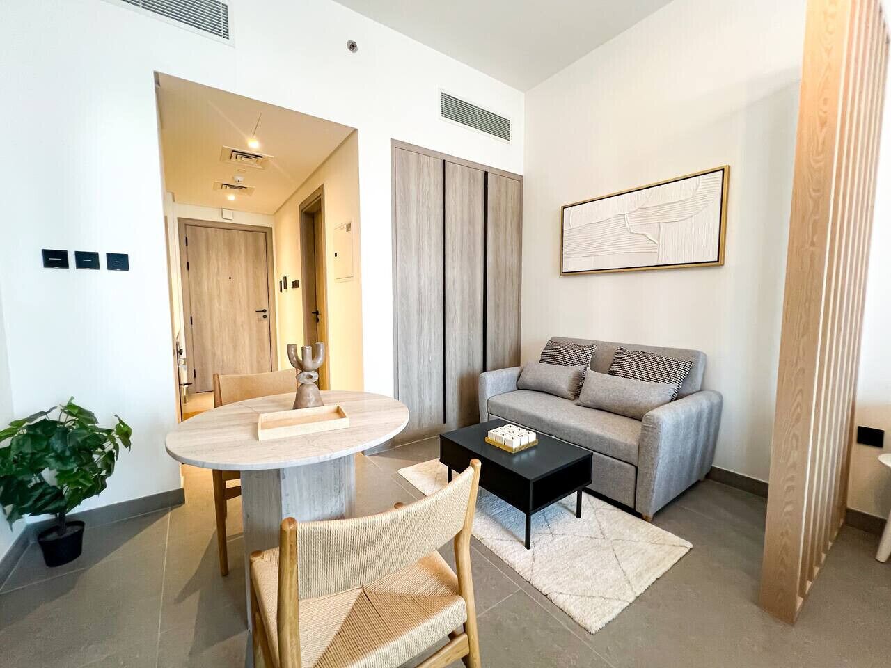 Una sala de estar moderna con una mesa redonda para comer, un sofá y una mesa de centro.