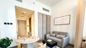 Uma sala de estar moderna com uma mesa de jantar redonda, um sofá e uma mesa de centro.