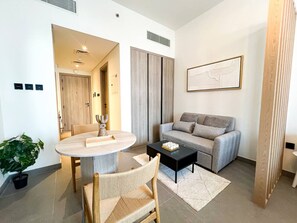 Ein modernes Wohnzimmer mit einem runden Esstisch, einer Couch und einem Couchtisch.