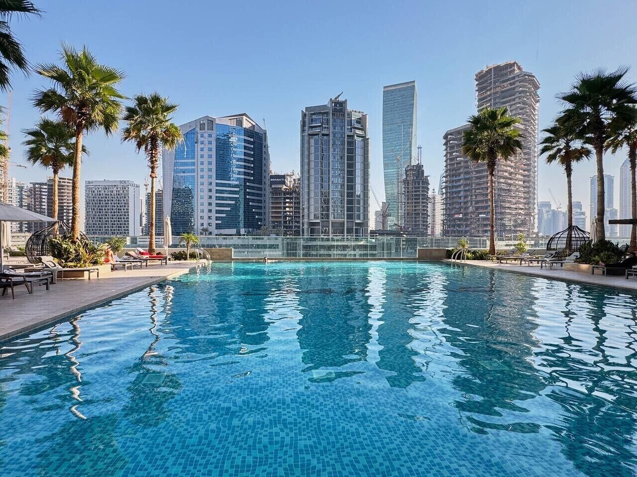 Una piscina con edifici cittadini sullo sfondo.