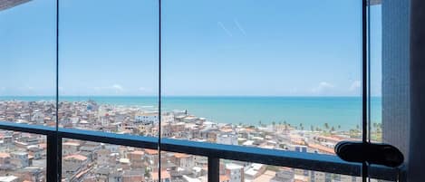 A cityscape with a view of the sea through a window.