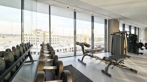 A gym with weightlifting equipment and a bench press. - Modern Studio | Rooftop Infinity Pool | Arjan (Dubai)