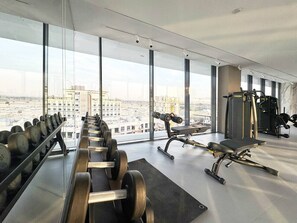 A gym with weightlifting equipment and a bench press. - Modern Studio | Rooftop Infinity Pool | Arjan (Dubai)