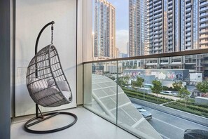 A modern interior with a hanging chair by a large window overlooking a cityscape. - Premium 1BR in Grande | Heart of Downtown Dubai (Dubai)