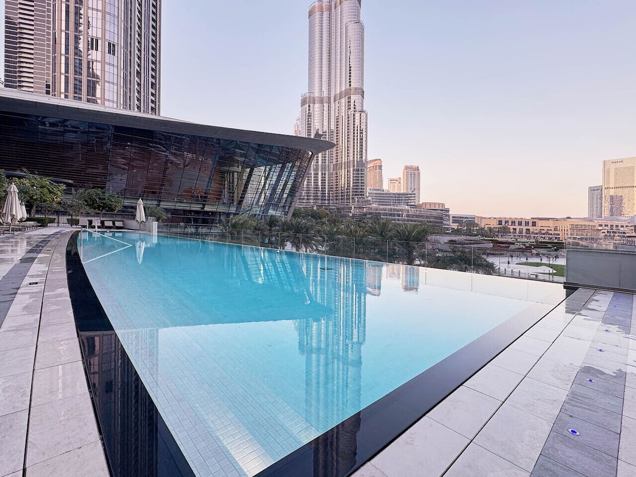 A rooftop infinity pool with a cityscape view, surrounded by modern buildings.