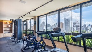 A gym with exercise equipment, large windows, and a city view. - Apartment 400m From Barra Beach Blb1306 (Salvador)